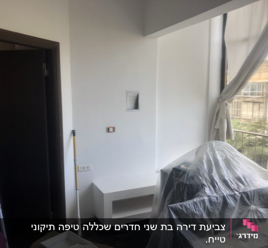 חדר עם קיר צבוע, רולר ומגש צבע